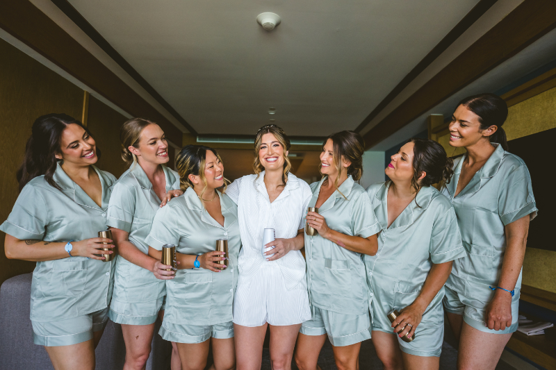 Bride with bridesmaids in matching outfits, destination wedding pros and cons getting ready moment
