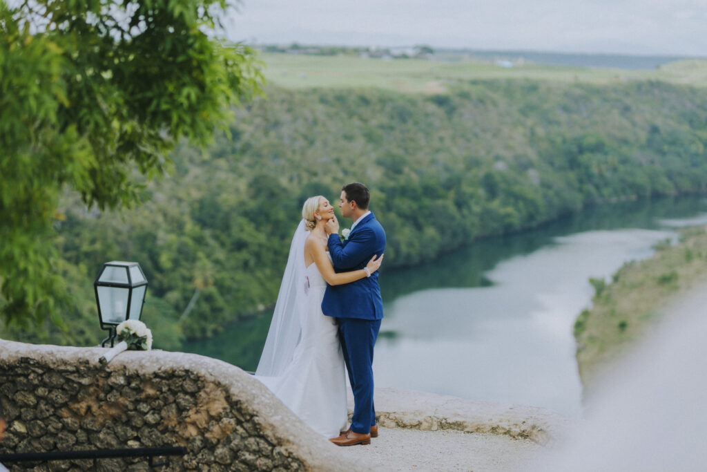 All inclusive destination wedding at Casa de campo. Couple posing in front of river.