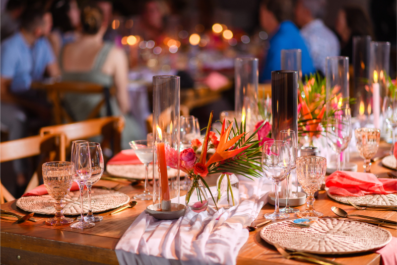 Destination wedding planner reception setup with tropical flowers, candlelit tablescape, and elegant beach wedding décor.