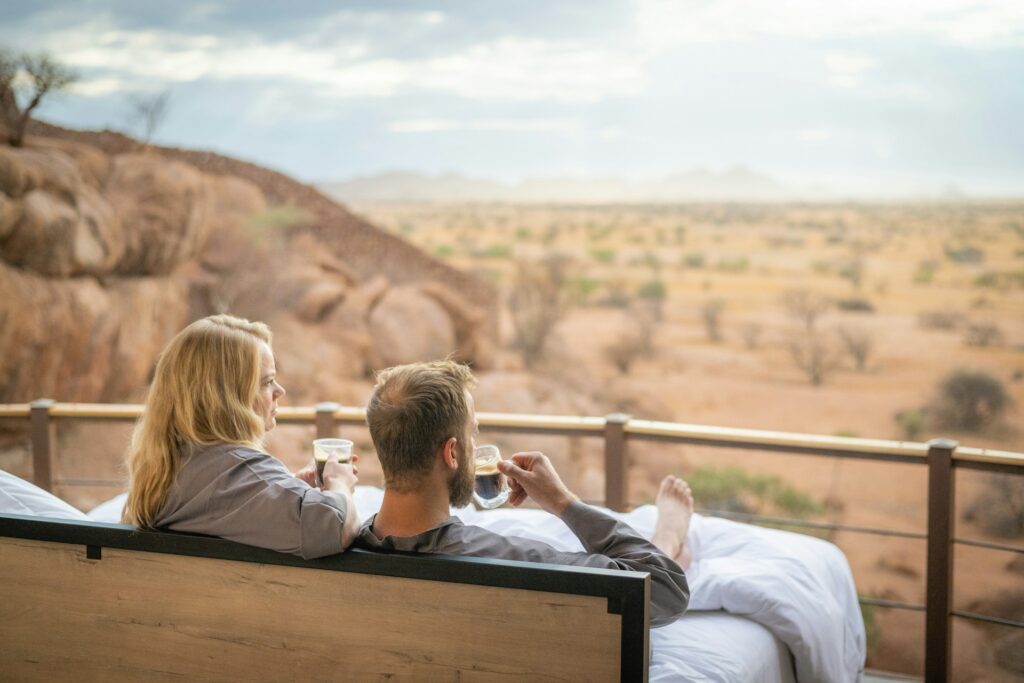 Honeymoon couple drinking coffee in the morning with a view of the savannah on safari